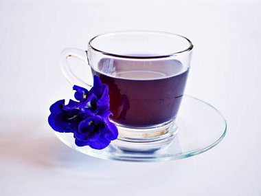 Beyaz bitki çayına ayrılmış mavi çiçekli bir fincan çay.