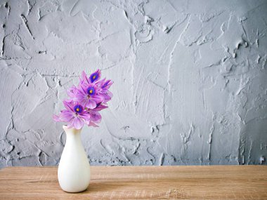 Purple flowers in vase on the table,Purple-pink flower still life on texture background or wallpaper Common water hyacinth Eichhornia crassipes Pontederia crassopes Kochuripana ,copy space for letter text wallpaper ,mother's day ,woman's day