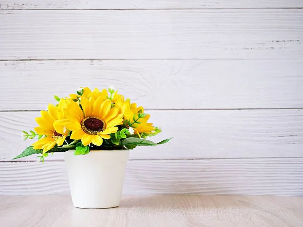 Yellow colored artificial Sunflowers bouquet in pot on table, Decoration copy space for text or lettering pretty background or wallpaper ,mother\'s day ,still life ,women\'s day festive background