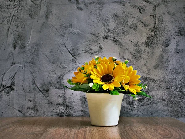 Yellow colored artificial Sunflowers bouquet in pot on table, Decoration copy space for text or lettering pretty background or wallpaper ,mother\'s day ,still life ,women\'s day festive background