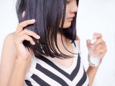 Siyah saçlı ve yağlı şişede E vitamini taşıyan bir kadın saç dökülmesini önlemek için kaba ve yumuşak. Otantik ince yapılı ve bronz tenli Asya Tayland. Sağlıklı ve güzel konsept için kozmetik.