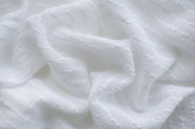 Beyaz kumaş pamuk arka plan. Soyut doku, lüks kumaş yumuşak dalga görüntüsü. boş alan arkaplanındaki ürünleri iyi kullanmak ya da tanıtmak için metin kullanabilirsiniz. Üst görünüm veya düz uzanma.