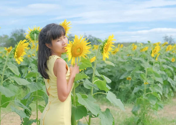 太陽の花公園と青空の背景に立って黄色のドレスを持つ肖像画だけ女性 テキストプレゼンテーションを追加するための無料スペース 黒髪と皮膚タン 休日の観光自然熱帯夏 — ストック写真