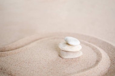 Kumsalda Zen Japon bahçe tasarımı desenli çakıl yığınları. Budizm zihin-manzarası sakin taş sembolleri.