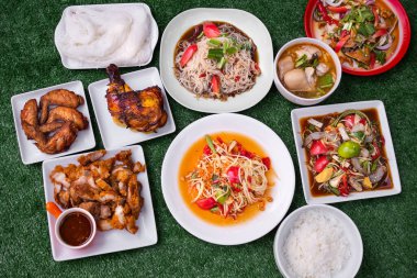 Papaya salatası, ızgara tavuk, Tayland pilavı şehriye, kızarmış domuz eti, domuz salatası ve Tayland yemeği. Düz katmanlı acı domates, limon ya da limon, taze karides, turşu balığı, sebze ve baharat..