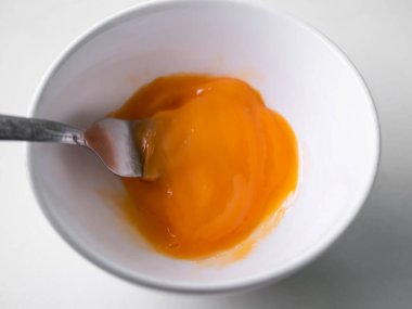 Yumurtayı çatalla beyaz bardakta yakın mesafeden çırp. Evde mutfakta yemek pişirmek. Çiğ yemek malzemesi. Sabah kahvaltısı. yüksek protein besin kavramı.