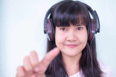 Happy woman wearing Headphones with laptop at home in holiday vacation.portrait Lady finger touch screen and smile.she Video call to friend.Technology internet communication for lifestyles concept.