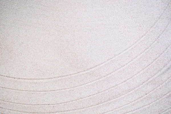 Texture line Japanese pattern on white sand background. buddhism texture wave on desert nature at coast of shore. top view line abstract on beach with stone. Purity Meditation calm or lifestyles spa.