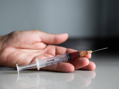 Elleri yerde, şırıngada eroin, Bağımlı Madde, Yasadışı madde, Tehlikeli Uyuşturucu kavramı.