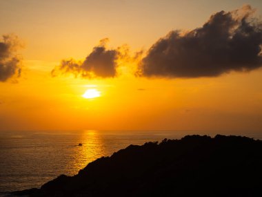 Gün batımında deniz kenarında. Güzel ufukta güneş ışığı arka planı. Turuncu bulutlu arka planlı deniz manzarası. Turist seyahati için tropikal yaz tatili ya da kırık kalp yalnızlığı konsepti.