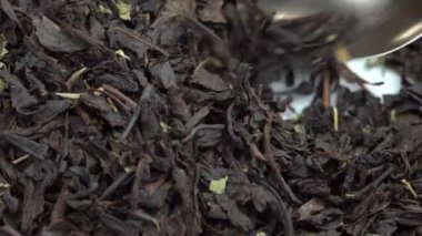 Kaşık kuru siyah çay yapraklarını, tabakta siyah çayları toplar.