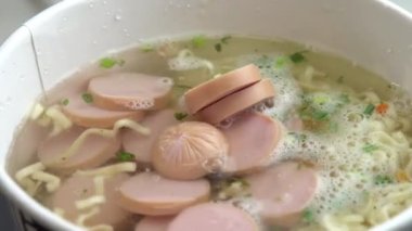 Dilimlenmiş sosisler mayalanmış hazır eriştelere, Asya usulü tatlı ve ekşi eriştelere dökülüyor.