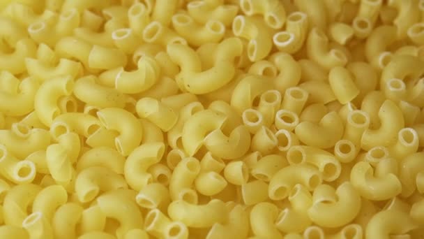 Macaroni kegels draaien in close-up. Achtergrond van spinnen Italiaanse pasta — Stockvideo