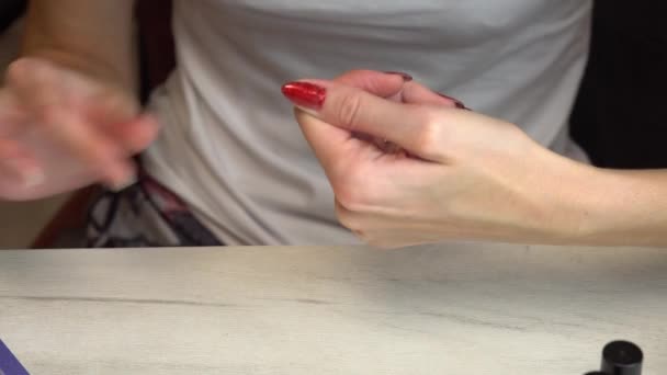 Chica corrige las uñas después de la manicura con una lima de uñas o tablas Emery — Vídeo de stock