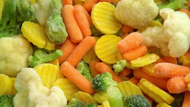 Verduras frescas congeladas que giran para obtener un fondo, alimentos saludables o alimentos dietéticos para vegetarianos y veganos, coliflor congelada, brócoli y zanahorias bebé — Vídeo de stock