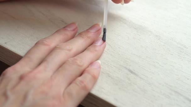 Применение базового пальто перед покрытием ногтей лаком для ногтей, самоманикюр дома — стоковое видео