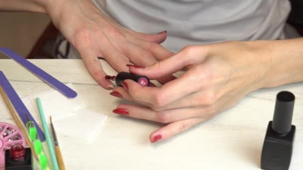 La ragazza applica smalto bordeaux sulle unghie, auto manicure, manicure a casa — Video Stock