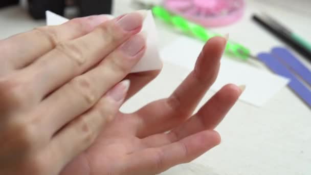 Een meisje ontvet nagels met een speciale vloeistof voor het aanbrengen van nagellak, het voorbereiden van nagels voor manicure — Stockvideo