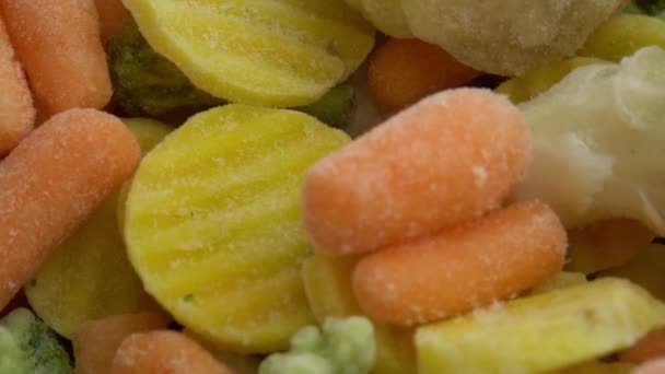 Świeże mrożone warzywa na wirującym tle, zdrowa żywność lub dieta dla wegetarian i wegan, mrożone kalafiory, brokuły i marchewki dla niemowląt — Wideo stockowe