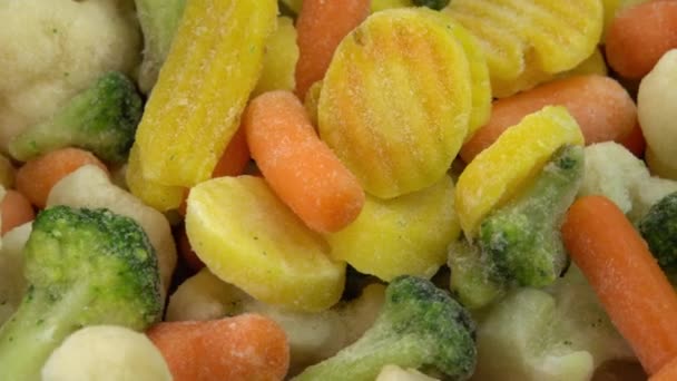 Verse diepvriesgroenten die roteren op achtergrond, gezond voedsel of dieetvoeding voor vegetariërs en veganisten, diepvriesbloemkool, broccoli en babywortelen — Stockvideo