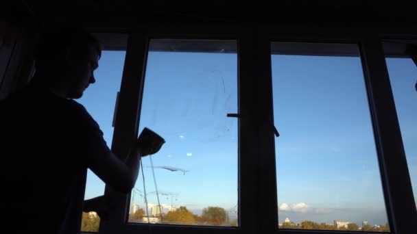 O cara lava a janela com um pincel magnético e limpador de janelas — Vídeo de Stock