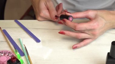 Kız, manikür, manikür, manikür gibi tırnaklarına oje sürüyor.