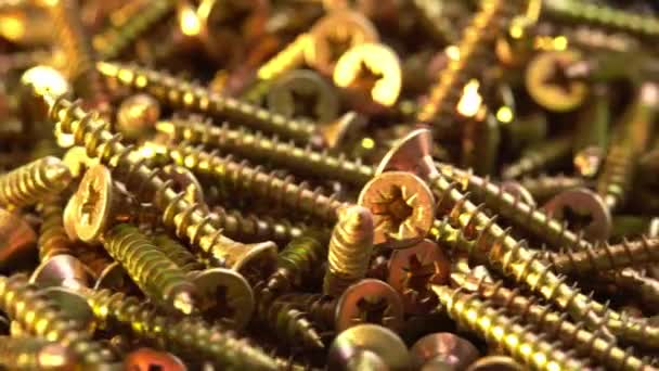 Golden screws or cross head screws rotate like background, construction supplies self-tapping screws or bolts — Stock Video