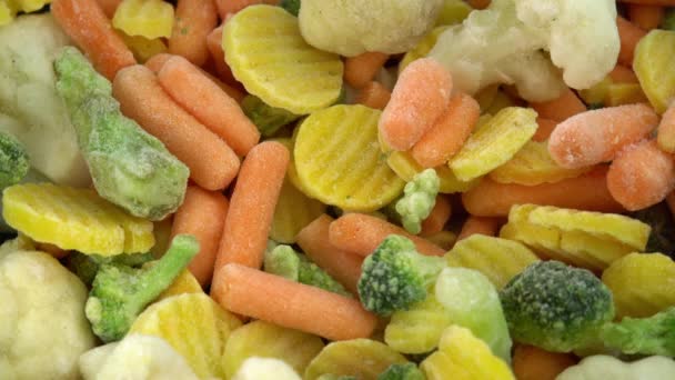 Świeże mrożone warzywa obracające się w tle, zdrowa żywność lub dieta dla wegetarian i wegan, mrożone kalafiory, brokuły i marchewki dla niemowląt — Wideo stockowe