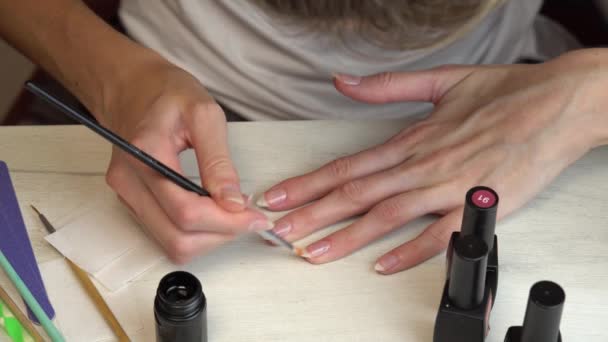 Aplicando um revestimento de base antes de revestir as unhas com esmalte, auto manicure em casa — Vídeo de Stock