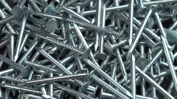 Stos metalowych gwoździ srebrnych do prac budowlanych obracają się jako tło, hobnails wirują z bliska tło, pin lub kolce do prac budowlanych — Wideo stockowe