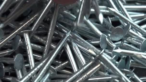 Stahlnägel aus Metall für Bauarbeiten, die auf eine rotierende Oberfläche fallen, Fingernägel drehen sich in Großaufnahme Hintergrund, Nagel oder Dorn für Bauarbeiten — Stockvideo