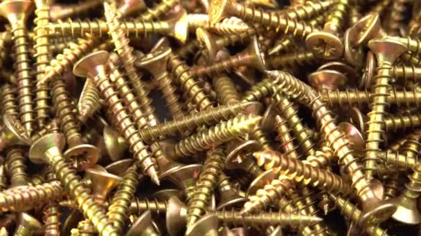 Golden screws or cross head screws rotate like background, construction supplies self-tapping screws or bolts — Stock Video