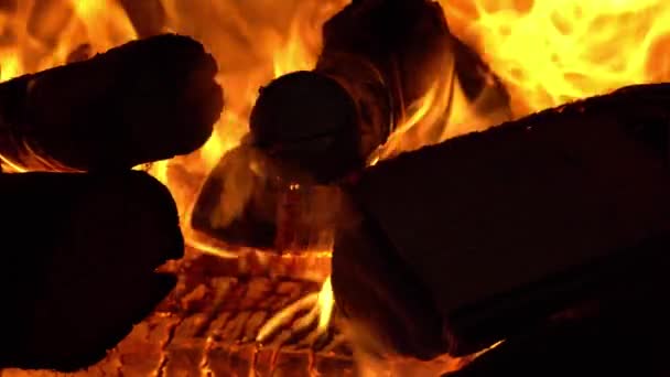 La leña se quema en la estufa, el horno está lleno de leña, la noche está junto a la chimenea — Vídeos de Stock