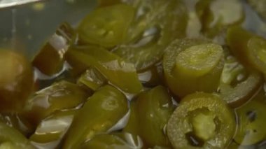 Çatal dilimlenmiş jalapeno biberi alır arka plan olarak döner, yakın plan jalapeno biberi turşusudur.