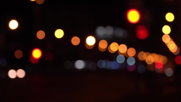 Runde bunte Bokeh leuchten von der Ampel im Stau auf der Stadtstraße. Wunderschönes glitzerndes Bokeh vor dunklem, verschwommenem Hintergrund in der Nacht. Abstraktes Konzept. Spiegelt einsamen Lebensstil in der Hauptstadt wider. — Stockvideo