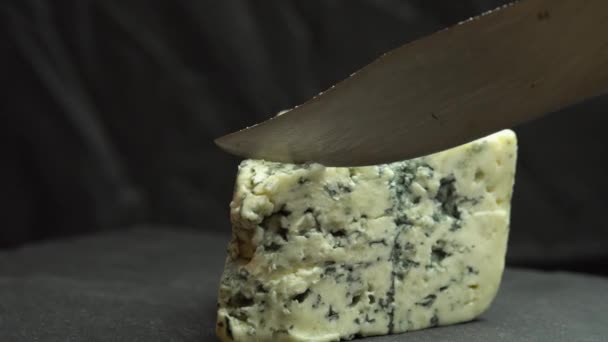 Cuchillo corta azul noble azul queso está girando en un plato. Textura de queso azul. Quesos azules fragantes con molde noble — Vídeos de Stock