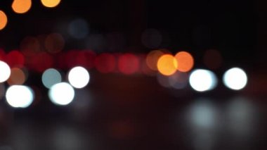 Soyut kavram. Şehir caddesindeki trafik sıkışıklığında araba ışıkları yuvarlak renkli bokeh parlıyor. Gecenin karanlığında bulanık arkaplanda güzel, ışıltılı bir bokeh. Yalnız başkent yaşam tarzını yansıtıyor..