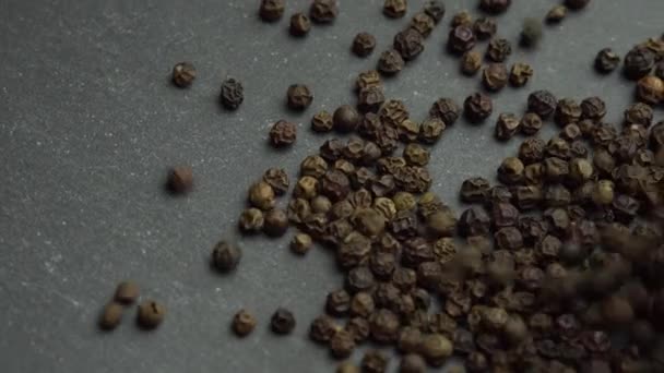 Le poivre noir est versé sur la plaque tournante, les grains de poivre noir — Video