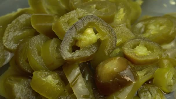 Poivrons jalapeno marinés tranchés tournent comme fond, gros plan de piments jalapeno marinés — Video