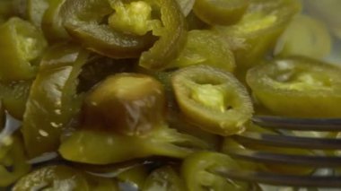 Çatal dilimlenmiş jalapeno biberi alır arka plan olarak döner, yakın plan jalapeno biberi turşusudur.