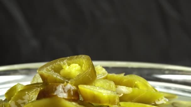 Nakrájené nakládané papričky jalapeno otáčet na talíři jako pozadí, zblízka nakládané chilli papričky jalapeno — Stock video
