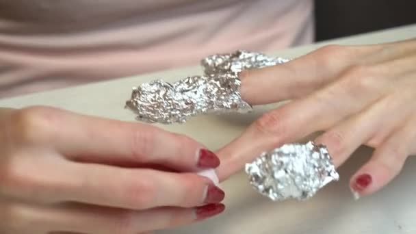 Preparing nails for manicure, fingers in foil. Selfmade manicure service. Manicurist paints nails with pink gel polish. Manicured red nails. Nail polish application. — Stock Video
