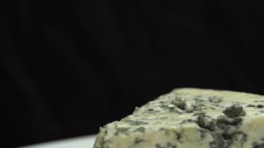 Asil kalıplı mis kokulu peynirler. Mavi peynirin dokusu. Mavi soylu mavi peynir tabakta dönüyor.