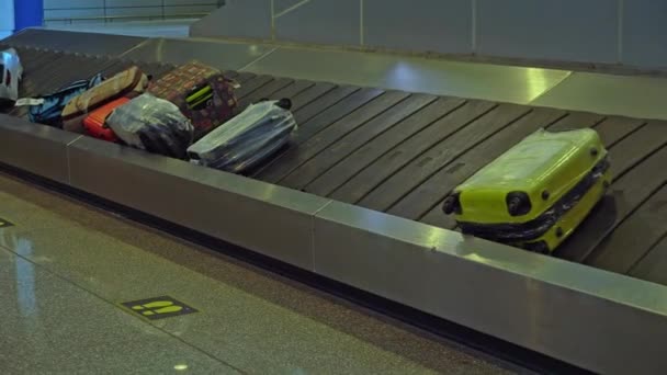 Equipaje en el carrusel de equipaje en el aeropuerto. Las maletas giran en la cinta después de desembarcar del avión. — Vídeos de Stock