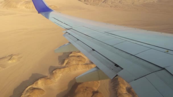 Flugzeug fliegt über die Berge und die Wüste, der Blick aus dem Fenster auf die Tragfläche des Flugzeugs und die Klappen. — Stockvideo