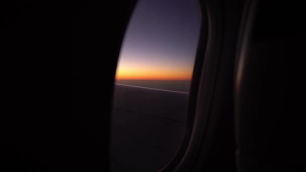 Вид из иллюминатора самолета пролетает над небом на закате или восходе солнца, вид из окна на крыло самолета и закрылки. — стоковое видео