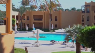 Stella Di Mare Plaj Tatil Köyü ve Hurgada 'daki SPA Makadi Körfezi Oteli. Ana havuz ve zemin manzarası. Rüzgarda dalgalanan palmiyeler: Mısır, Hurgada - 2 Aralık 2021