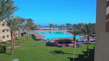 Kızıl Deniz manzarası ve Makadi Körfezi 'ndeki Tia Heights adlı Mısır otelinin bölgesi. Hurghada 'daki en iyi yüzme havuzu ve palmiye ağacı manzarası: Mısır, Hurghada - 3 Aralık 2021