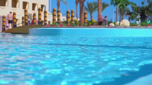 Turistas paseos por el resort tropical, vista de la piscina en un día soleado en el resort paradisíaco. — Vídeos de Stock