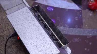 Sabun köpüğü yapmak için bir makine. Sabun köpüğü üfleme makinesi. Büyük baloncuklar otomatik siyah balon makinesinden dışarı üflenir.. 